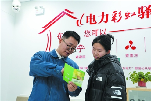 聂文君(左)正在向客户介绍安全用电知识